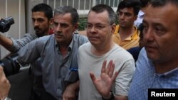 Andrew Brunson (tengah), pendeta evangelis AS, tiba di rumahnya setelah dibebaskan dari penjara dan dipindah menjadi tahanan rumah di Izmir, Turki, Rabu (25/7). 