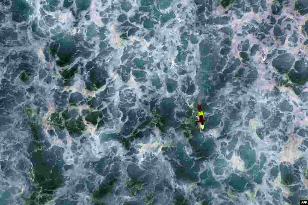 An aerial view shows a surfer on his board at the Praia de Cruz beach in Sal Rei on Boa Vista island, Cape Verde, Jan. 1, 2020.