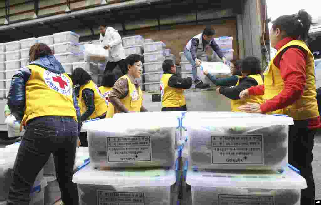Para anggota Palang Merah Korea Selatan mengeluarkan paket-paket bantuan darurat dari sebuah truk di Terminal Kargo Bandar Udara Incheon, Incheon, Korea Selatan (14/11). (AP/Ahn Young-joon)