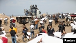 Palestinci nose vreće brašna koje su uzeli iz kamiona pomoći u blizini izraelskog kontrolnog punkta u gradu Gaza.