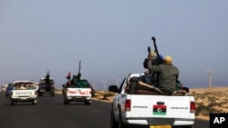 A convoy of rebels travel in the direction of Libyan leader Moammar Gadhafi's hometown of Sirte city near Bin Jawad, March 28, 2011