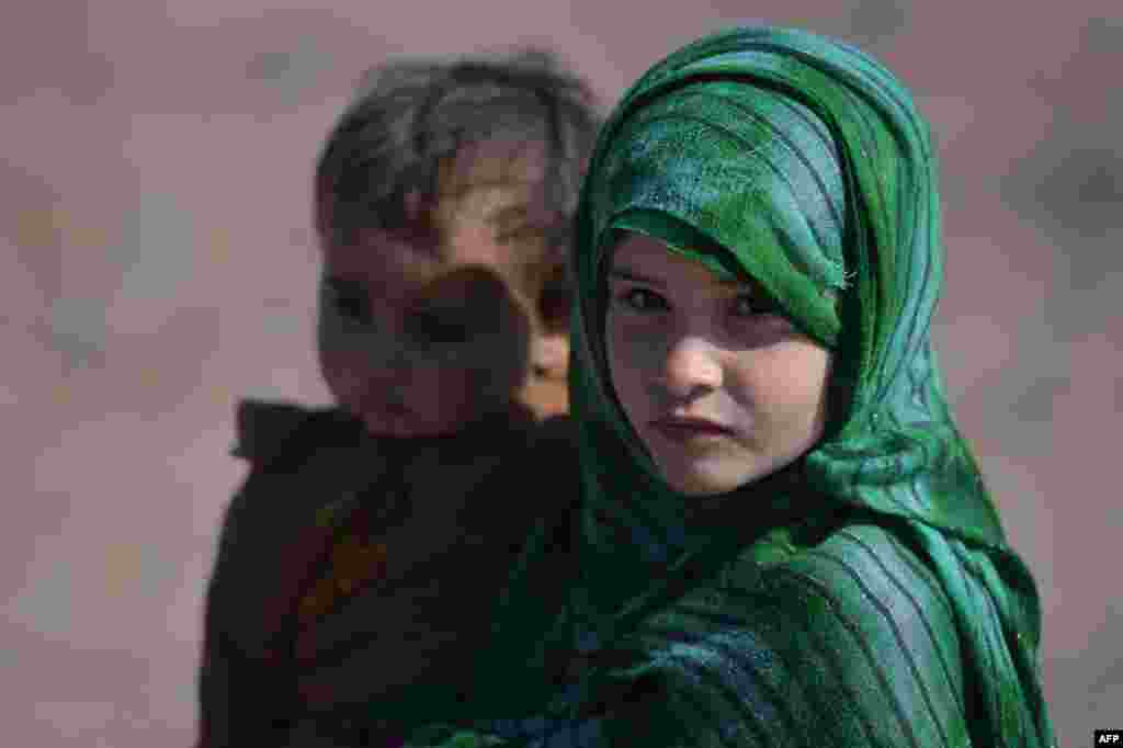 تصویری از دختر مهاجر افغان به همراه برادرش در اردوگاه پناهندگان در اسلام آباد &nbsp;