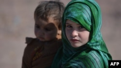 Une jeune Afghane et son frère dans un camp de réfugiés à la périphérie d'Islamabad, le 1er février 2018.