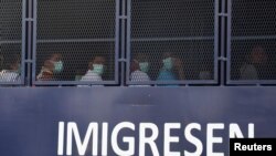 Myanmar migrants to be deported from Malaysia are seen inside an immigration truck, in Lumut, Malaysia, Feb. 23, 2021.