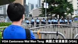 香港年青抗爭者6-12警民衝突前隔著鐵馬觀看特首辦入口的警方防線 （攝影：美國之音湯惠芸）