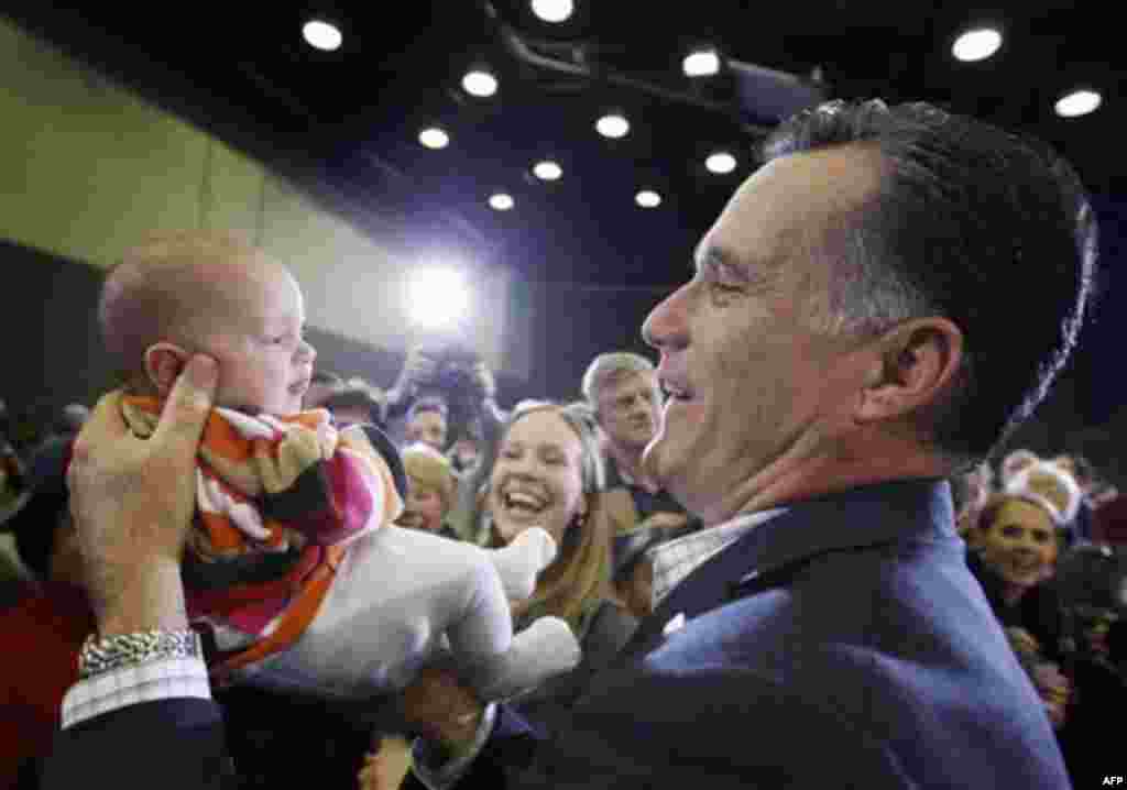 Republican presidential candidate, former Massachusetts Gov. Mitt Romney, picks up nine-week-old Laura Ensley from Augusta, Ga., as her mother, Mary Ensley watches at center, as he campaigns at the University of South Carolina Aiken, in Aiken, S.C., Frida