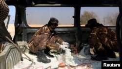 FILE - Afghan security personnel inspect a car filled with explosives which was seized from a Taliban insurgent in Jalalabad, Afghanistan Dec. 10, 2019.