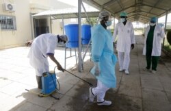 Medical personnel spray disinfectant outside the ward where COVID-19 patients are receiving treatment, at the Farcha provincial hospital in N'Djamena, Chad, April 30, 2021.