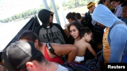 Central American migrants line up at a bridge that connects Guatemala to Mexico.