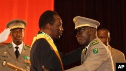 Presiden sementara Mali, Dioncounda Traore (tengah) mendapat ucapan selamat dari pemimpin kudeta Amadou Haya Sanogo, usai pelantikan di Bamako (12/4) 