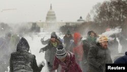 Warga bermain salju saat cuaca dingin melanda Washington DC Maret tahun lalu (foto: dok).