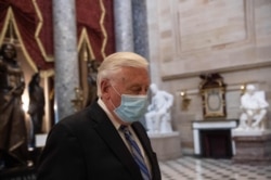 FILE - U.S. Rep. Steny Hoyer, D-Md., wears a face mask as he walks out of the House chamber during the debate on pandemic aid measures, at the U.S. Capitol in Washington, April 23, 2020.
