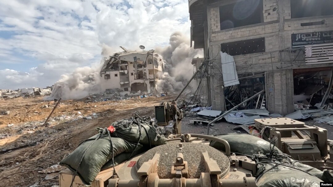 Asap mengepul dari sebuah gedung saat tentara Israel beroperasi di Jalur Gaza, dalam tangkapan layar yang diambil dari video selebaran yang dirilis pada 4 Desember 2023. (Foto: via Reuters)