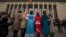 Uighur ethnic minority delegates in their traditional dresses pose for photos as they walk towards the Great Hall of the People for the opening session of the annual National People's Congress in Beijing, China, March 5, 2012. 