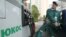 FILE - A worker fills up a car at Yukos gas station in Moscow.