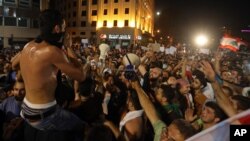 Lebanese anti-government protesters use bullhorns to chant slogans during a demonstration in downtown Beirut, Aug. 29, 2015.