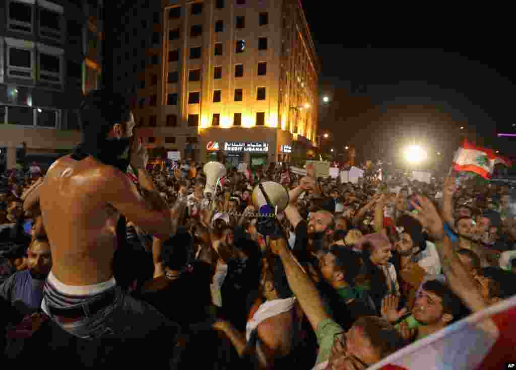 Para demonstran meneriakkan slogan-slogan anti-pemerintah dalam unjuk rasa di pusat kota Beirut (29/8). (AP/Bilal Hussein)