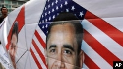 A man holds a banner depicting US President Barack Obama during a pro-Obama rally in Jakarta, 19 Mar 2010