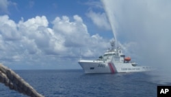 In this Sept.23, 2015 photo provided by Renato Etac, Chinese Coast Guard members approach Filipino fishermen as they confront them off Scarborough Shoal at South China Sea, in northwestern Philippines. (Renato Etac via AP)