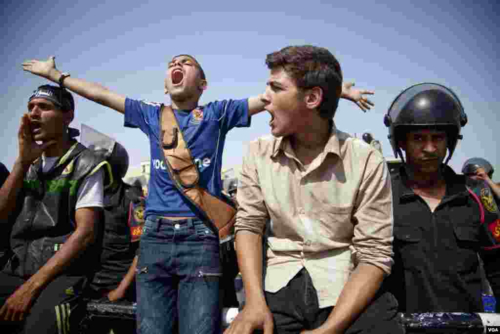 Young anti-Mubarak protesters chant outside of the Cairo courthouse where former Egyptian president Hosni Mubarak awaited a verdict in his trial, June 2, 2012. (VOA/Y. Weeks)