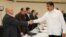 FILE - Venezuela's President Nicolas Maduro, right, shakes hands with Jesus Torrealba, left, secretary of Venezuela's coalition of opposition parties, during a political meeting between government and opposition, in Caracas, Venezuela, Oct. 30, 2016.
