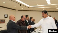 Prezidan venezuelyen an, Nicolàs Maduro, ki tap bay lanmen ak sekretè jeneral Kowalisyon Opozisyon Demokratik la (MUD), Jesùs Torrealba, pandan yon rankont ki dewoule Caracas nan jounen dimanch 30 oktòb 2016 la. (Foto: REUTERS/Palè nasyonal Miraflores). 