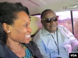 The CDC's Paulyne Ngalme Ntuba, left, confers with an aide to Guinea's prime minister, Mohamed Said Fofana, en route from Forecariah on Sept. 27, 2014. (Carol Guensburg/VOA)