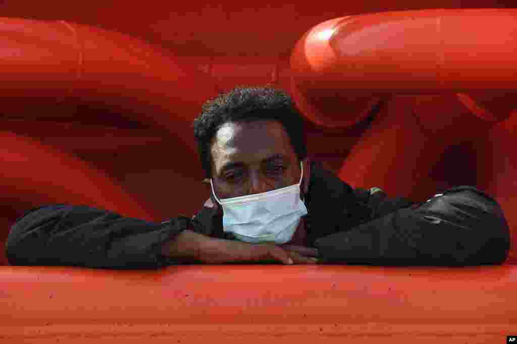 A man aboard the Asso Trenta ship waits to be transferred on the quarantine ship Gnv Azzurra, on the Sicilian island of Lampedusa, southern Italy.