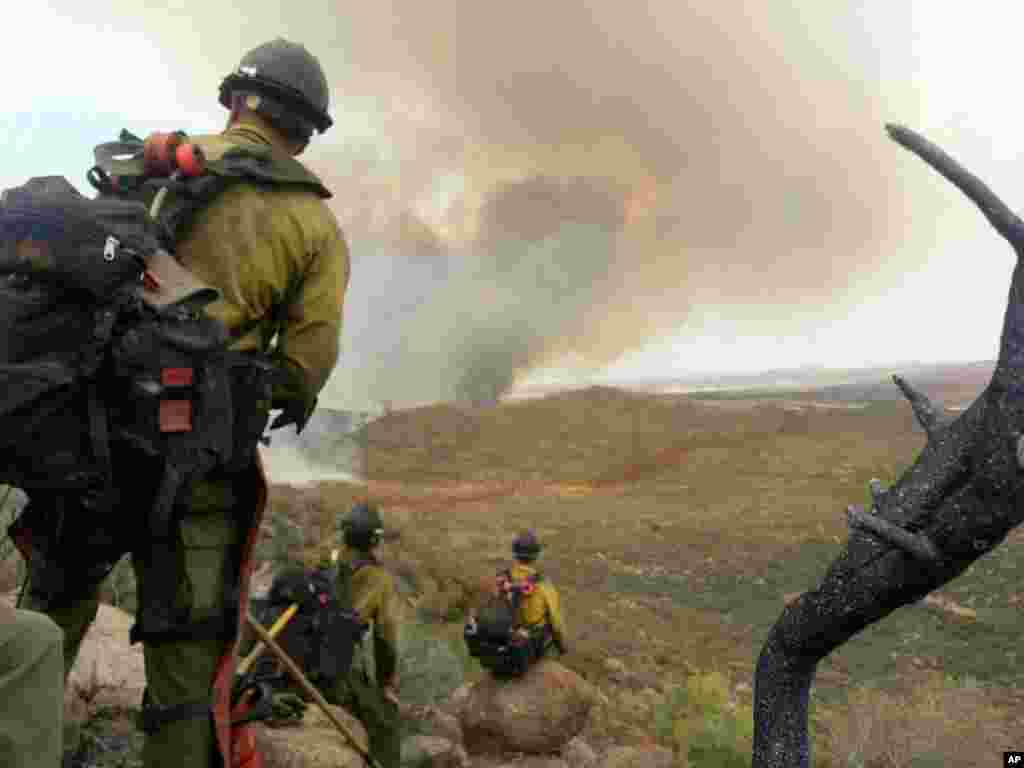 In this photo shot by firefighter Andrew Ashcraft on June 30, 2013, members of the Granite Mountain Hotshots watch a growing wildfire that later swept over and killed the crew of 19 firefighters near Yarnell, Arizona. 