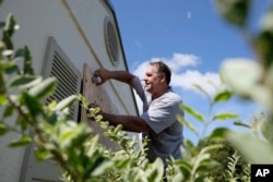 With Hurricane Irma threatening to march through Florida, Ben Tozour installs wood shutters on his home in the Cutler Bay section of Miami, Sept. 8, 2017.