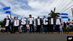 En esta foto del 30 de mayo de 2018, los manifestantes antigubernamentales portan un cartel donde se lee "Justicia", durante una marcha contra el presidente del gobierno de Nicaragua, Daniel Ortega, y su esposa, la vicepresidenta Rosario Murillo.