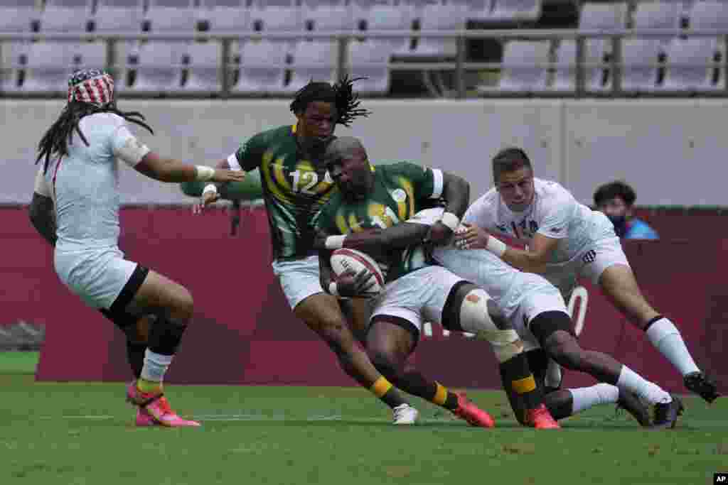 South Africa&#39;s Siviwe Soyizwapi gets tackled by Carlin Isles of the United States, in their men&#39;s rugby sevens match at the 2020 Summer Olympics, Tuesday, July 27, 2021 in Tokyo, Japan. (AP Photo/Shuji Kajiyama)