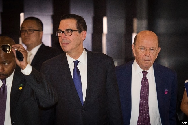 2018年5月4日，美国财政部长史蒂文·努钦（左）和美国商务部长威尔伯·罗斯（右）穿过酒店大堂，前往钓鱼台国宾馆与中国官员进行贸易谈判。
