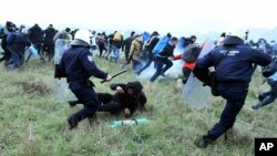 Polisi anti huru-hara bentrok dengan para migran yang berunjuk rasa di luar kamp pengungsi di desa Diavata, sebelah barat Thessaloniki, utara Yunani, 6 April 2019 (foto: AP Photo/Giannis Papanikos)