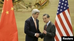  U.S. Secretary of State John Kerry shakes hands with Chinese Foreign Minister Wang Yi after arriving at the Ministry of Foreign Affairs in Beijing, China, on Jan. 27, 2016.