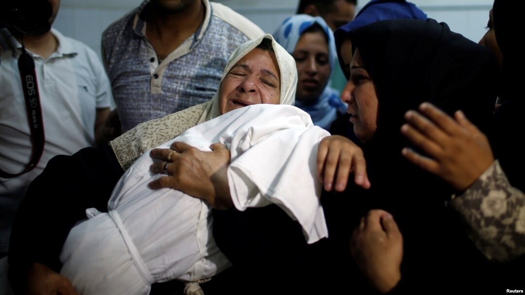 A relative mourns as she carries the body of 8-month-old Palestinian infant Laila al-Ghandour, who died after inhaling tear gas during a protest against the U.S. embassy move to Jerusalem, at the Israel-Gaza border, during her funeral in Gaza City, May 15, 2018.
