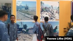 Sekelompok pelajar yang menyaksikan foto-foto dokumentasi dampak bencana alam yang dipajang dalam kegiatan pameran khusus sejarah alam dan kebencanaan oleh Museum Sulawesi Tengah, 8 Oktober 2019. (Foto: VOA/Yoanes Litha)