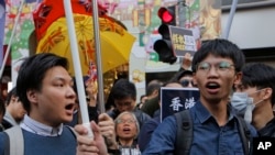 FILE: In this Jan. 1, 2019, photo, pro-independence demonstrator Tony Chung, right, marches during an annual New Year protest in Hong Kong.