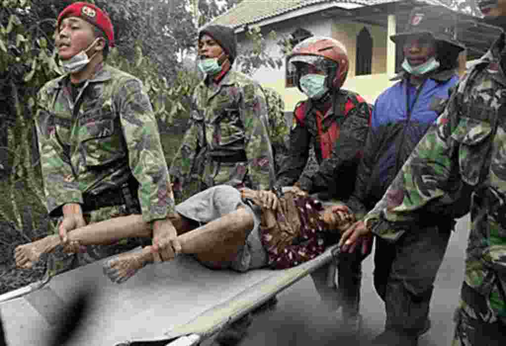 Indonesian soldiers evacuate an elderly woman who refuses to leave her house in Ngerangkah, Yogyakarta, Indonesia, Saturday, Oct. 30, 2010. Indonesia's military forced villagers off the slopes of the country's most volatile volcano Saturday as it unleashe