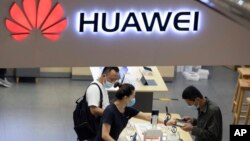 Para pengunjung melihat-lihat produk-produk buatan Huawei di sebuah toko di Beijing, 15 Juli 2020. (Foto: Ng Han Guan/AP Photo)