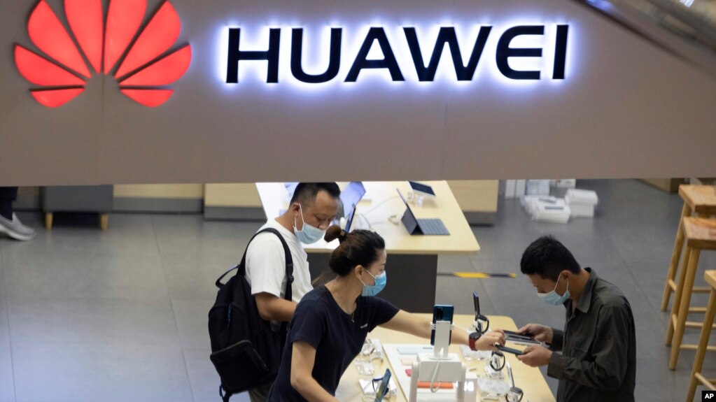 Visitors wearing masks to curb the spread of the coronavirus look at the latest products at a Huawei store in Beijing on Wednesday, July 15, 2020. (AP Photo/Ng Han Guan)