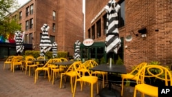 Empty chairs lines a sidewalk outside a restaurant Washington's Georgetown district, April 29, 2020. The coronavirus is sending the U.S. economy into the biggest and fastest collapse since the Great Depression, with economic output reported.