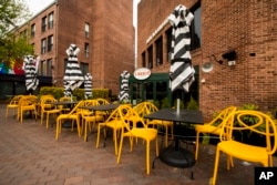 Empty chairs lines a sidewalk outside a restaurant Washington's Georgetown district, April 29, 2020. The coronavirus is sending the U.S. economy into the biggest and fastest collapse since the Great Depression, with economic output reported.