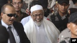 Radical cleric Abu Bakar Bashir, center, leaves the court after the judges delivered his sentence during his trial at a district court In Jakarta, Indonesia, June 16, 2011