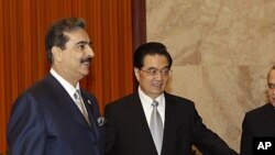 Pakistani Prime Minister Yousuf Raza Gilani, left, is shown the way by Chinese President Hu Jintao during a meeting at the Great Hall of the People in Beijing, May 20, 2011