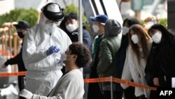 수십 명의 신종 코로나바이러스 집단 감염이 발생한 서울의 한 콜센터 건물에서 10일 방역복을 입은 의료진이 건물 내 다른 근무자들의 검체를 체취하고 있다.