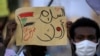 A demonstrator holds up a sign reading in Arabic "peace first, Nertiti sit-in" along with a drawn Sudanese flag, during a protest in the Garden City district of Sudan's capital Khartoum on July 4, 2020.