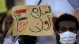 A demonstrator holds up a sign reading in Arabic "peace first, Nertiti sit-in" along with a drawn Sudanese flag, during a protest in the Garden City district of Sudan's capital Khartoum on July 4, 2020.