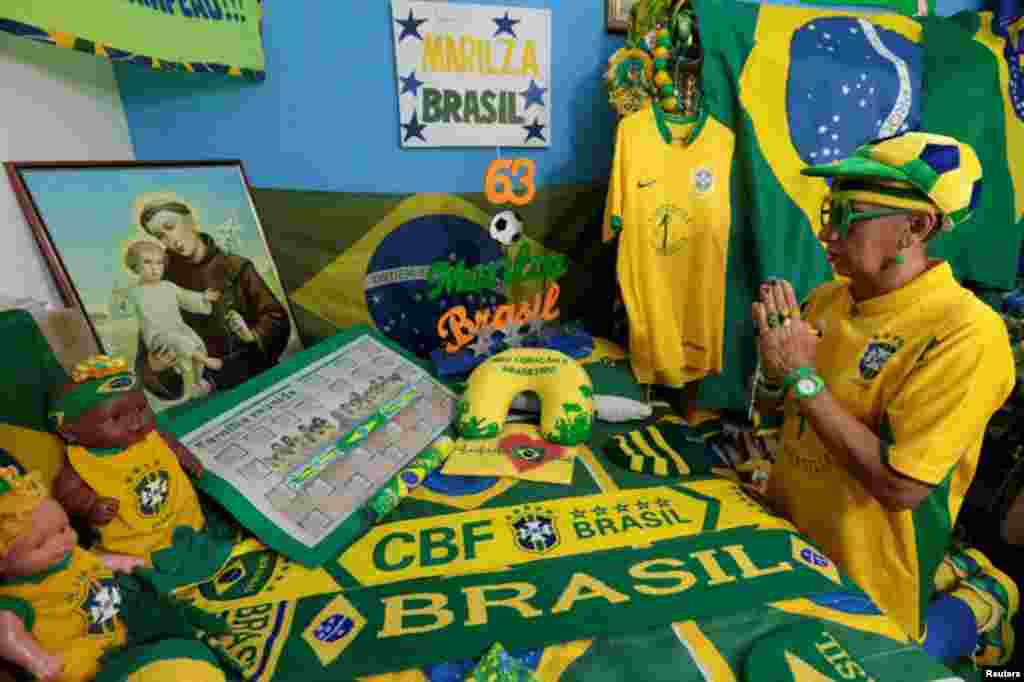 A senhora de 63 anos, Marilza, reza no seu santuário, todo decorado com os elementos da selecção brasileira, na sua casa em Brasília, Maio 27, 2014. REUTERS/Joedson Alves