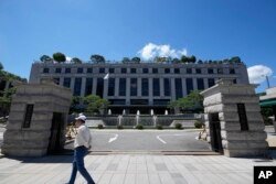 Seorang pria berjalan di depan Mahkamah Konstitusi di Seoul, Korea Selatan, Kamis, 29 Agustus 2024. (Lee Jin-man/AP)